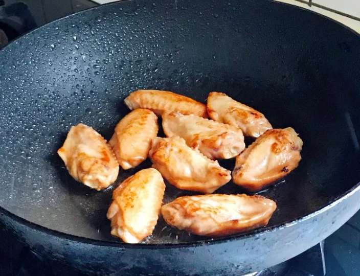 照烧鸡翅,醃好的鸡翅用中小火慢煎，煎至两边呈金黄色即可。（裡面没熟透也没关係，等一下还要燜煮）