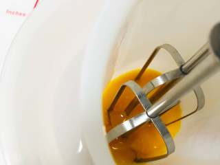 黑芝麻蛋黄溶豆,先打发蛋黄。放一碗温水，将装蛋黄的容器放在温水中，我们需要隔着温水打发蛋黄，这个就是增加溶豆成功率，不会消泡的小窍门哦！