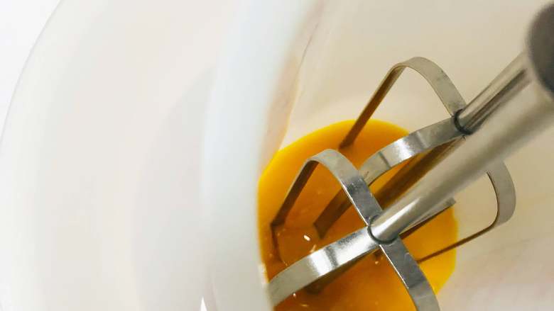 黑芝麻蛋黄溶豆,先打发蛋黄。放一碗温水，将装蛋黄的容器放在温水中，我们需要隔着温水打发蛋黄，这个就是增加溶豆成功率，不会消泡的小窍门哦！