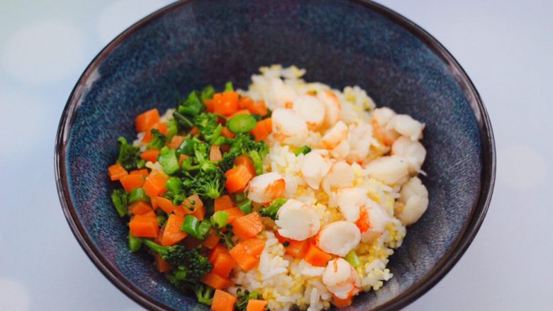阿根廷红虾时蔬二米饭团,把蒸好的二米饭，放入一个大一点的容器里，上面放入焯过水的胡萝卜和西兰花，切丁的红虾。