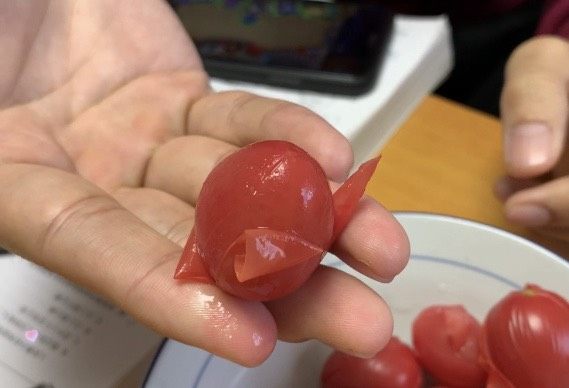 陈皮小番茄,将小番茄的皮撕下去，尽量保持小番茄完美。