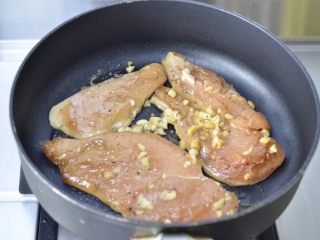 蒜香蜜汁黑椒鸡排,将鸡胸肉连同汤汁一起倒入锅中，盖盖 小火慢煎