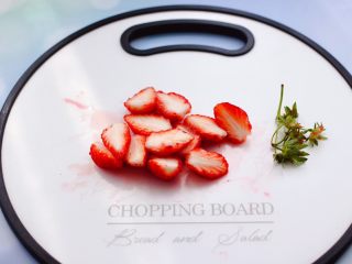 车厘子草莓冰奶昔,把草莓蒂摘掉不要，用刀把草莓一切两半。