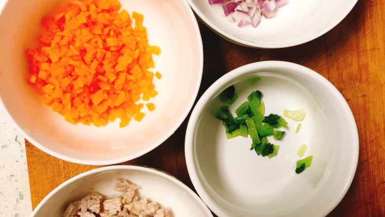 猪肉蔬菜手抓饭,把胡萝卜，洋葱，切碎！上海青冷水入锅焯水1分钟后快速捞出过下凉水切碎备用！