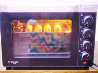 爆浆芝士火腿土司卷,放入烤箱中层，上下火180度烤6分钟即可。