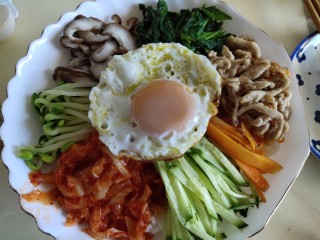 专治没食欲的韩式拌饭,盛两碗饭，摆上配菜，放上蛋，