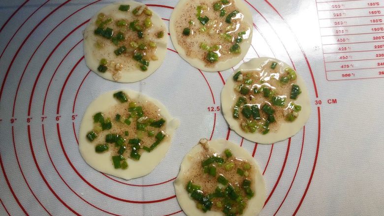 葱油饼,取出几片饺子皮摆在垫板上，用刷子刷上葱花油。