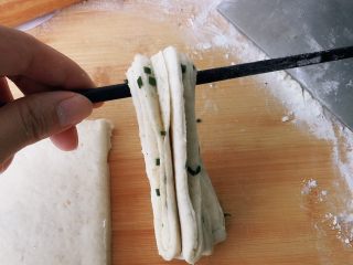 全麦香葱花卷,用筷子从中间提起，右手压住下端捏紧，拿筷子的手转360度