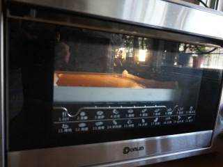 脏脏蛋糕卷,烤箱提前10分钟预热到170度，放入烤盘，烘烤18分钟左右（实际烘烤温度要根据自家烤箱脾气而定）。烘烤结束，将蛋糕取出，晾3分钟后立即倒扣在晾架上，趁热撕去底部的油纸，晾凉