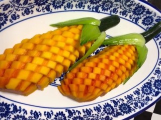 金瓜玉米,切好的木瓜摆在盘中，用鲁菜和黄瓜改成玉米的造型