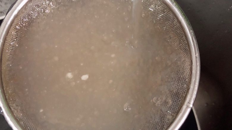杨梅奶昔西米露,煮好的西米在锅中焖5-10分钟。用凉水冲洗粘稠的汁液。