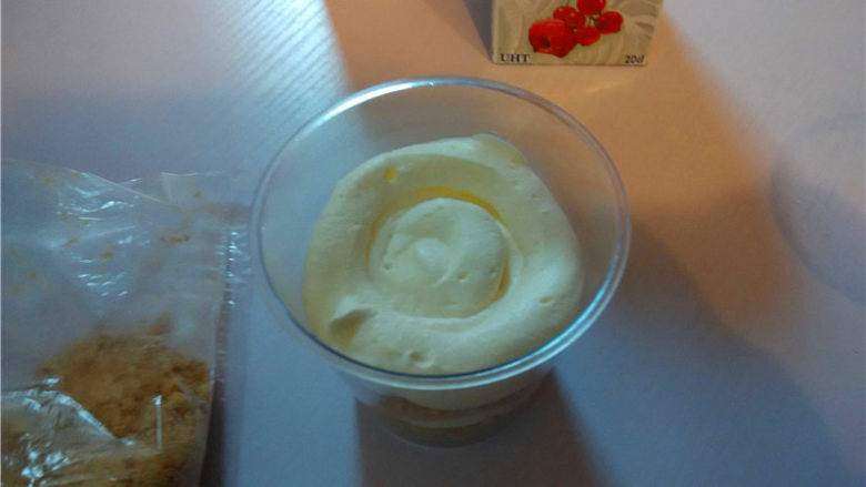 木糠杯,将淡奶油装入一个裱花袋中，裱花袋尖角出剪一个半厘米的小口。然后由内向外挤一圈奶油（可加点水果），再铺一层饼干碎，依次交替