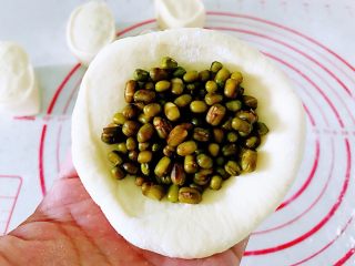 水煎绿豆玫瑰花馒头,稍微揉一下成圆形，擀成厚一点的圆薄片，中间挖一勺子煮好的绿豆放入，像包包子一样包起来。