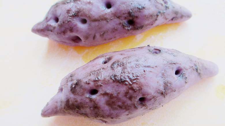 仿真紫薯包,表面喷上少许水，涂抹上少许奥利奥粉，营造紫薯泥土部分