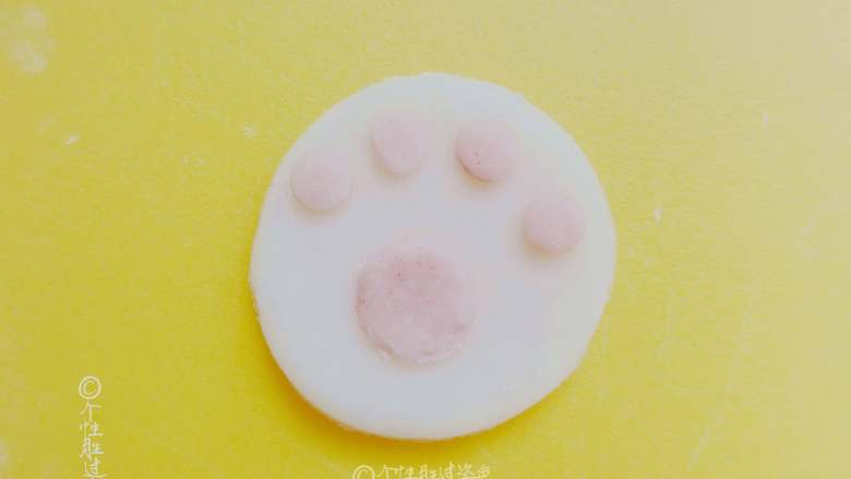 猫爪馒头,白色面团刷上少许水，把粉色的圆形面按照猫爪形状沾好