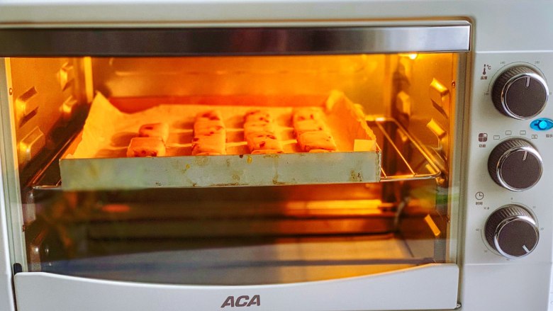 蔓越莓奶酥,放入预热至170度的烤箱中层，上下火烘烤20分钟左右，烤至表面呈金黄色即可出炉。