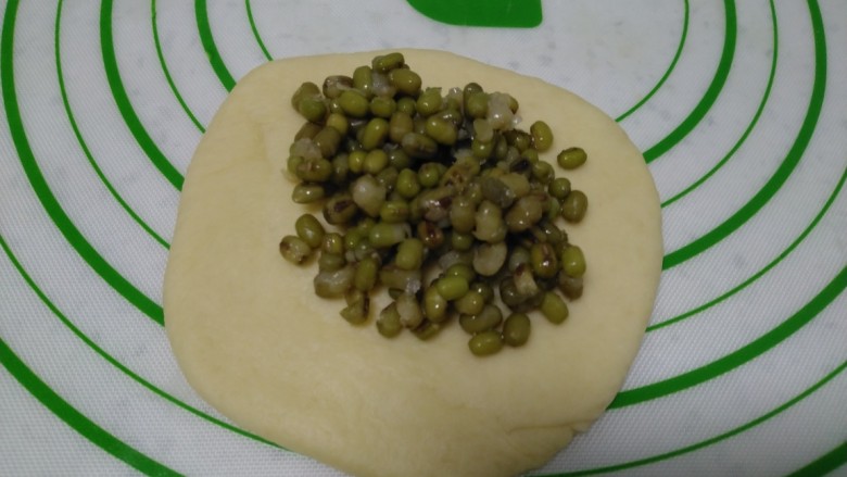 绿豆面包,取一个剂子擀成薄片，包入馅料。