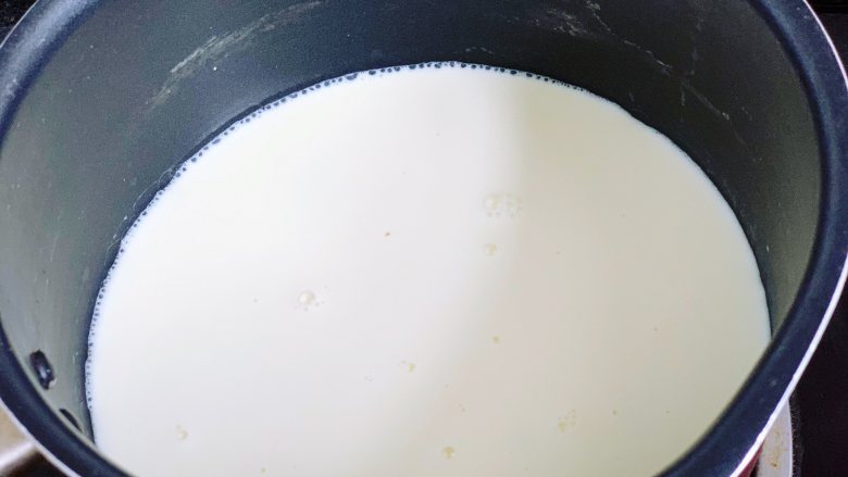 芒果双皮奶,接着将牛奶倒入奶锅里，小火加热，加热至四周冒起小泡泡，温度大概在80度左右即可关火，千万不要煮沸，否则很难形成奶皮。