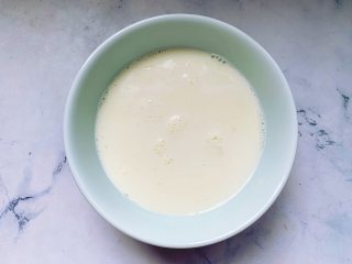 芒果双皮奶,将加热好的牛奶迅速倒入一个准备好的碗里，放在通风处晾凉，牛奶冷却后，表面会凝固成一层薄薄的奶皮。