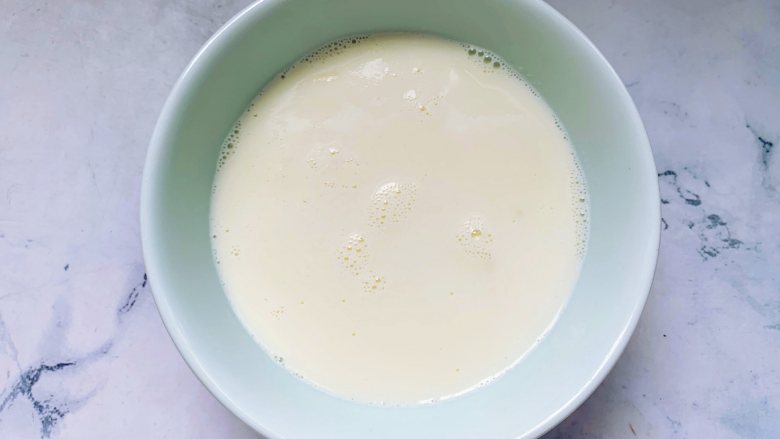 芒果双皮奶,将加热好的牛奶迅速倒入一个准备好的碗里，放在通风处晾凉，牛奶冷却后，表面会凝固成一层薄薄的奶皮。