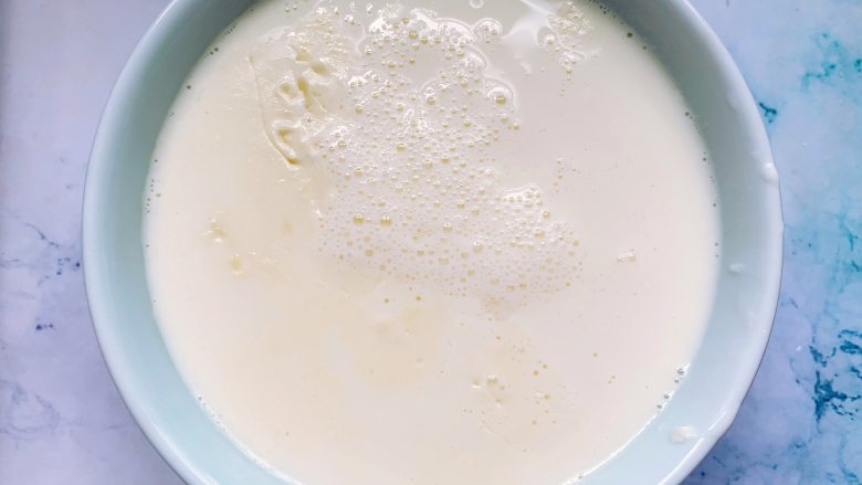 芒果双皮奶,待牛奶冷却后，用筷子轻轻挑起一侧奶皮，将牛奶倒入另一个碗里，碗底留少许牛奶，这样奶皮就不会粘在碗上，否则就会浮不起来。
