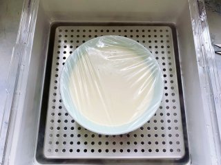 芒果双皮奶,接着在碗的表面盖上保鲜膜，用牙签戳几个洞，放入电蒸锅里。