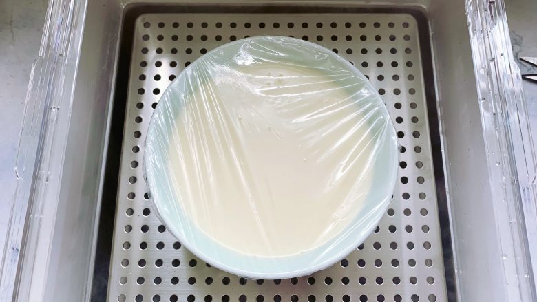 芒果双皮奶,接着在碗的表面盖上保鲜膜，用牙签戳几个洞，放入电蒸锅里。