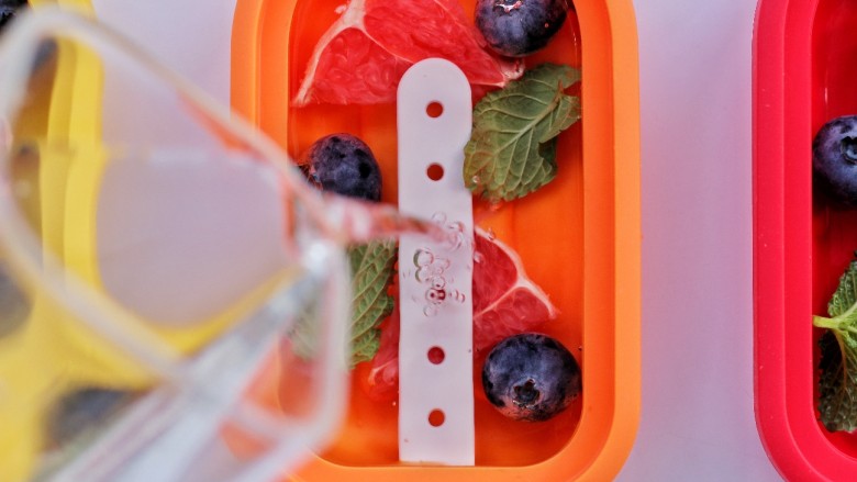 解暑降温新技能，西柚蓝莓薄荷冰棒,依次倒入模具中，盖上盖子。