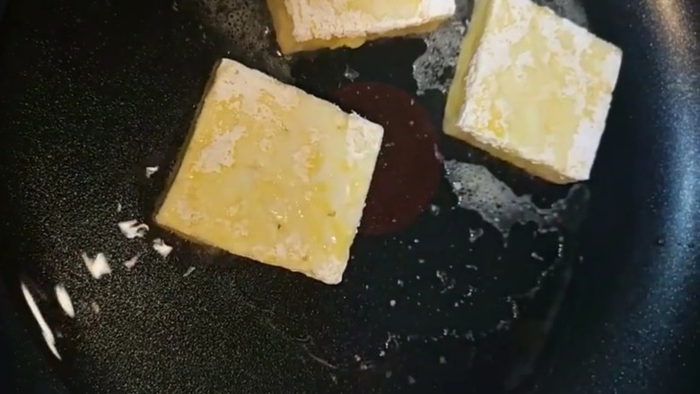 香煎豆腐,锅中油热下入豆腐