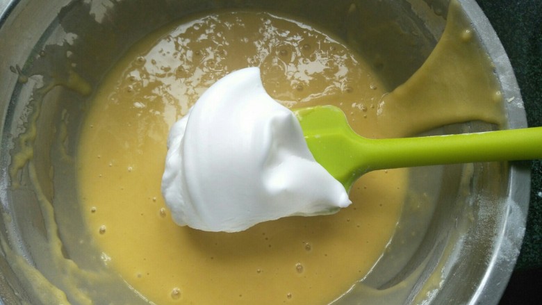 白雪公主蛋糕,将蛋白分三次加入蛋黄糊中用快速切拌的方法拌均匀后再放下一次蛋白。