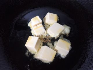 茄汁金银豆腐,锅里放油，把裹上蛋液的豆腐放进去煎。