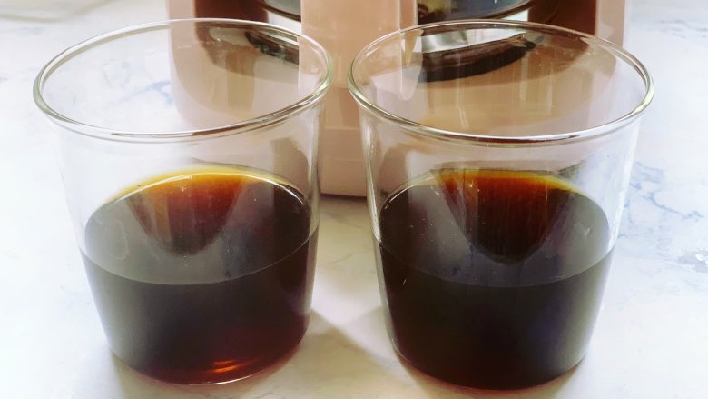 焦糖双色咖啡奶冻,将咖啡液体过筛一遍，分别加到两个提前准备好的玻璃杯里，两杯咖啡的分量要均等。