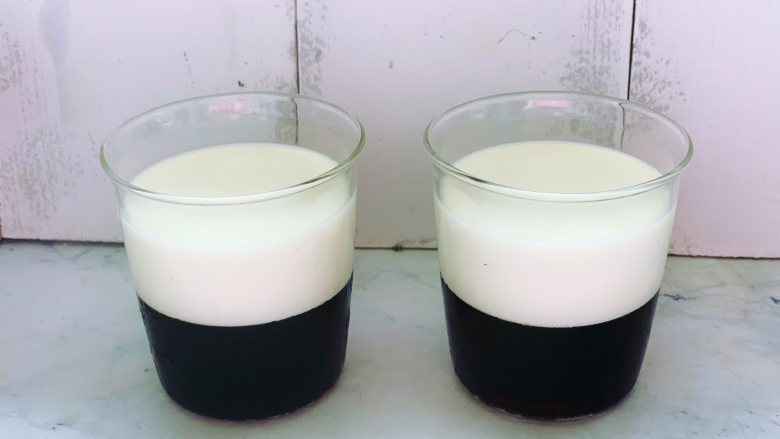焦糖双色咖啡奶冻,取出凝固好的两杯咖啡冻，分别加入放凉的牛奶液体，两杯的容量一样。