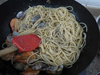 蒜蓉海鲜意大利面,加入黑胡椒和欧芹碎，如果面有点干可以加点热水。