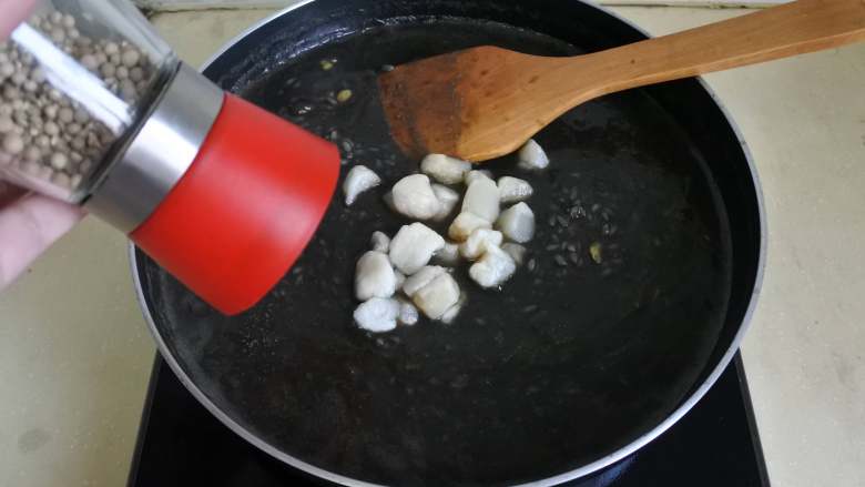 煎南美虾球配意式墨汁海鲜烩饭,加盐、胡椒粉调味
