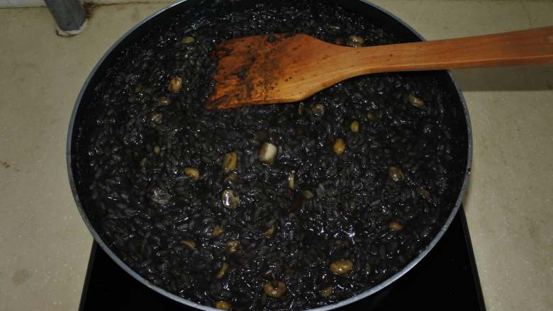 煎南美虾球配意式墨汁海鲜烩饭,把米煮粘稠，但不要收干汤汁，稍微湿润一点，取出香叶