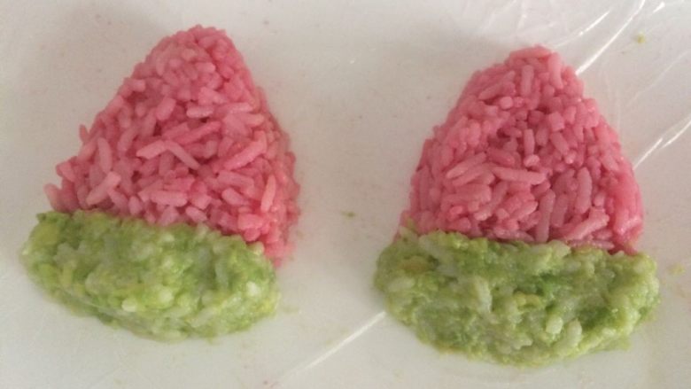 小盆友喜欢的西瓜饭团,粉色米饭完成造型后，再用绿色米饭捏出一个小长方形，贴在粉色米饭下面；
