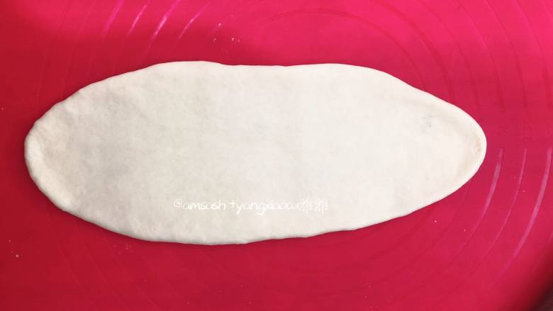 奶香排包,取一个小面团，把小面团擀成椭圆形，借助刮板把面团翻面