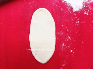 椰蓉面包(波兰种),取一个小面团，把小面团擀成椭圆形，借助刮板把面团翻面