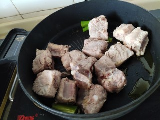 懒人排骨焖饭,放入葱段炒香，放排骨炒出肥肉部分的油脂