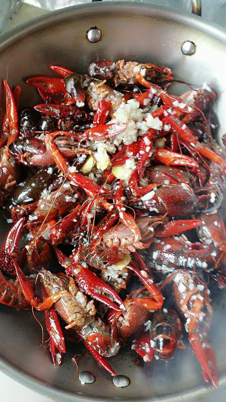 蒜泥小龙虾,倒入小龙虾，生姜，红辣椒，翻炒至虾壳变红，多翻炒一会让虾肉变紧。