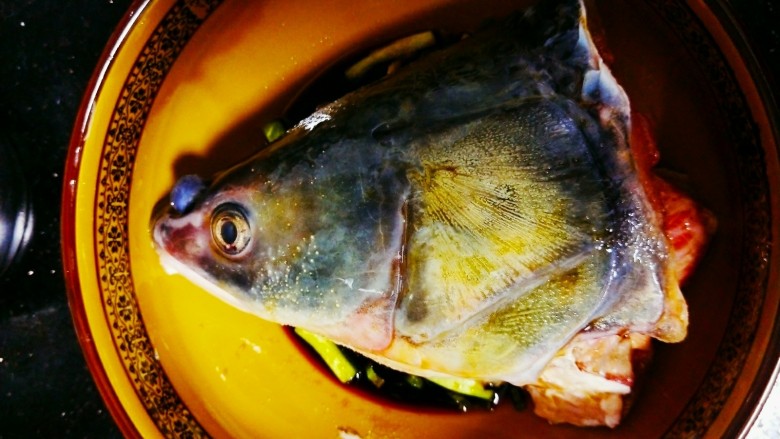 剁椒鱼头,将腌制的鱼清洗干净后放入碗中，加入蒸谷鱼