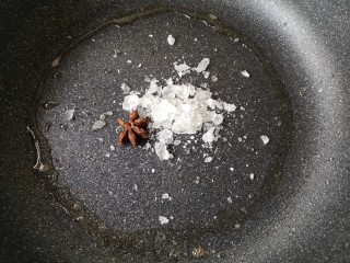 梅子排骨,锅中留适量底油将冰糖敲碎和八角一起下锅。