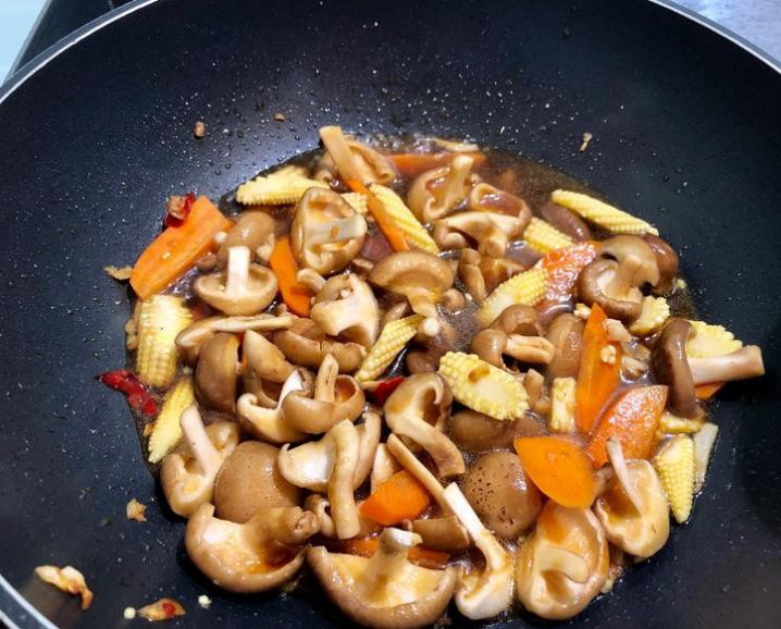 塔香鲜菇玉米笋,调味料倒入锅中拌炒收汁