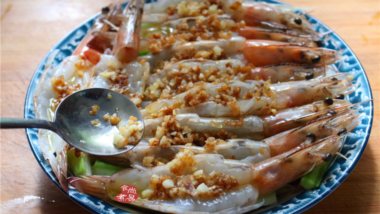蒜蓉丝瓜蒸海虾,将混合炒香的蒜蓉酱油用汤匙舀起，均匀铺在海虾上面；