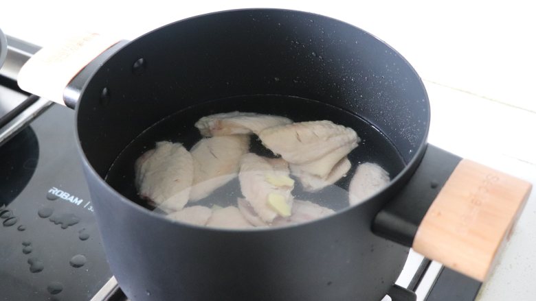 超级下饭菜，可乐鸡翅,把姜片和鸡翅一起放入冷水锅中，加盖烧开。