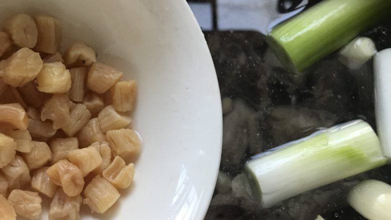 鸡汤馄饨,放入切好的葱段、少许的蒜瓣和适量的瑶柱。