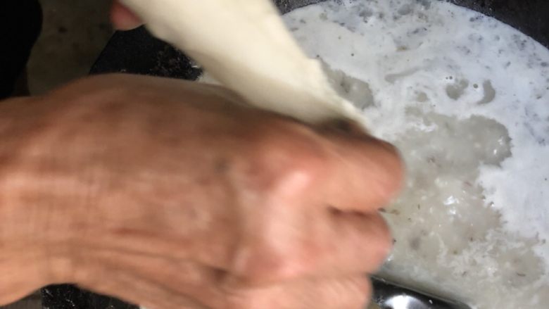 鱼肉汤面片（面疙瘩）,一手握面团，一手揪捏出面片。