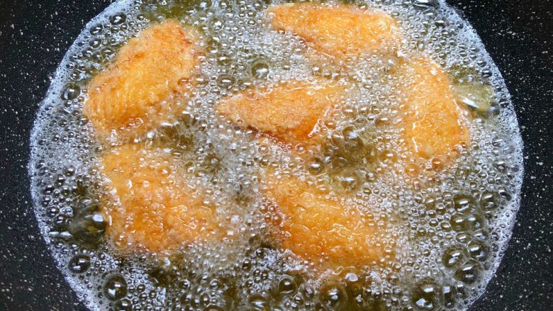 香酥鸡翅,热锅放入500毫升油，烧至7成热，把鸡翅一个个放到油锅里，待鸡翅定型再转中小火慢炸。