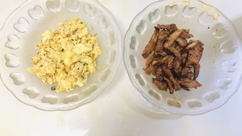 青菜炒面,炒锅中烧油，分辨把鸡蛋和瘦肉炒熟，然后盛出来备用。